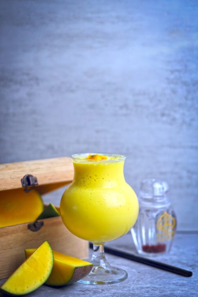 A vibrant mango smoothie served in a sleek glass for a refreshing healthy treat.